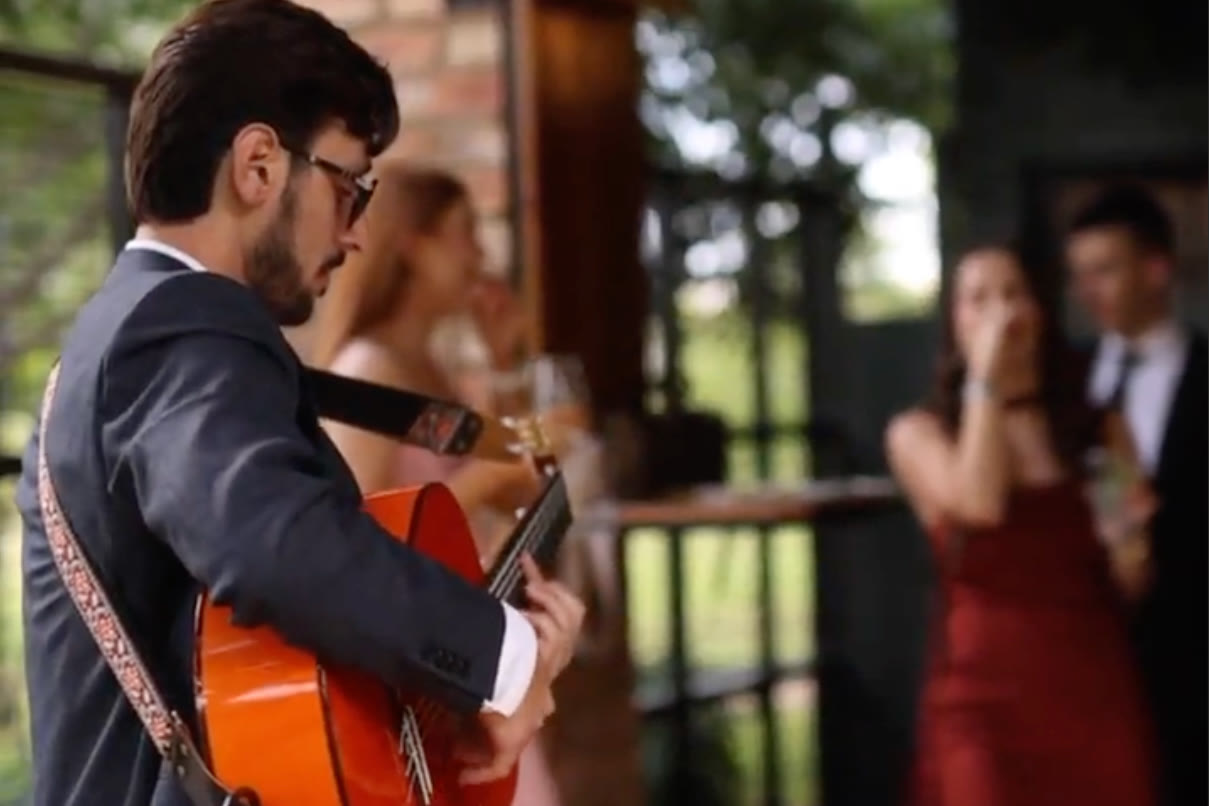 Guests at a wedding cocktail hour with live Spanish guitar